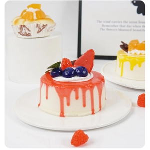 Detailed view of realistic 10cm fake mousse cakes with fruit toppings and liquid glaze