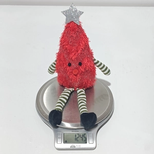 Detail shot of a plush red Christmas tree toy weighing 124.5g on a digital scale