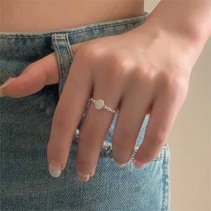 Macro detail of S925 sterling silver chain ring with smooth oval surface on finger