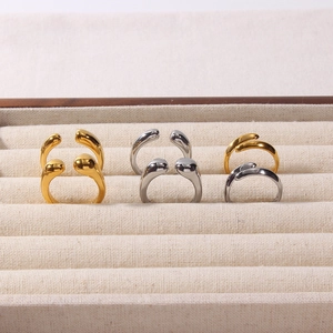 Detailed view of teardrop open rings in gold and silver finish on jewelry display