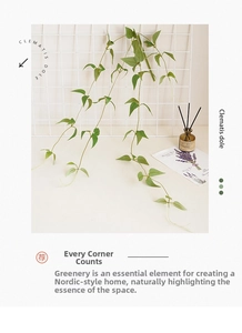 Detail of lifelike artificial clematis vine with green leaves hanging on a metal grid