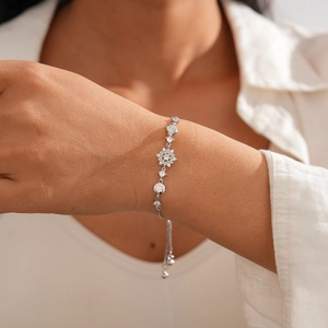 Macro detail of silver zircon snowflake bracelet with adjustable slide clasp on wrist