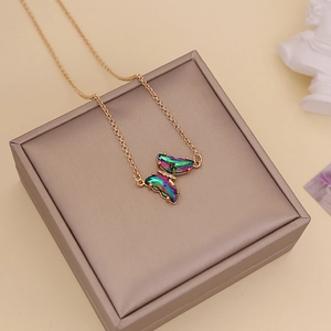 Detailed shot of an iridescent butterfly pendant with crystals on a golden chain