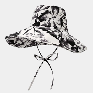 Détail d'un chapeau de soleil à fleurs noir et blanc avec rubans de serrage assortis