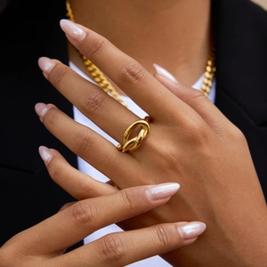 Close-up of a minimalist 18K gold stainless steel knot ring worn by a model