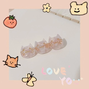 Detail of three connected pink translucent cat-shaped hair clips with gold accents