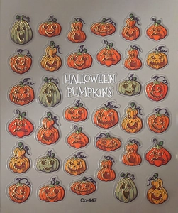 Detail of 3D Halloween pumpkin nail stickers with gold foil outlines and varied expressions