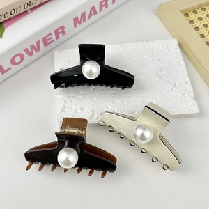 Elegant hair claw clips set with large pearls in black, brown, and beige colors
