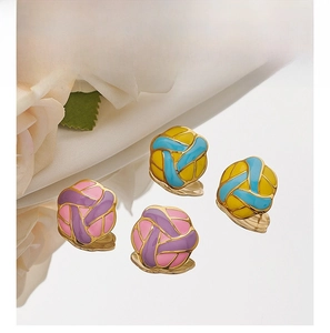 Detailed shot of enamel woven flower stud earrings with gold plating and mirror reflections