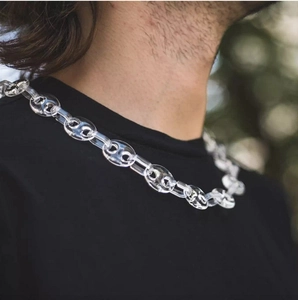 Detail of transparent chunky acrylic chain necklace on model in outdoor natural light
