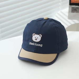 Detailed embroidery of a white bear and text on a navy and khaki cotton baseball cap