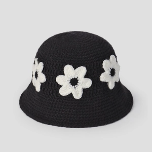 Détail d'un chapeau cloche au crochet avec trois fleurs blanches 3D sur fil noir