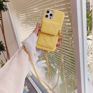 Detail of yellow quilted phone case featuring a wallet pocket and golden chain strap