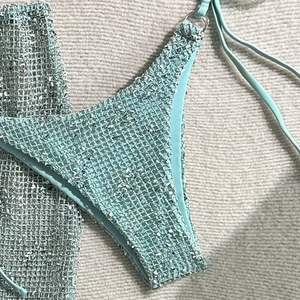 Detail of mint green tweed bikini with woven texture and metallic ring hardware accents