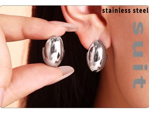 Macro view of polished oval stainless steel earrings showing the smooth liquid metal finish