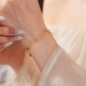 Close-up of a double-layered vintage gold flower bracelet on a model's wrist