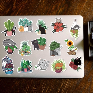 Waterproof cartoon cat and plant stickers applied on a silver laptop lid for DIY decoration