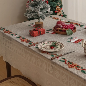 Close-up of Christmas table runner with embroidered snowmen and red lace borders