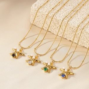 Detail showing four gold starfish necklaces with pearl inlays and colorful center stones