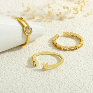 Detailed view of three 18K gold plated zircon rings including safety pin and star designs