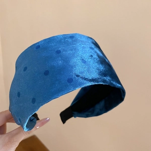 Detailed texture of bright blue flocked polka dot headband with velvet fabric finish