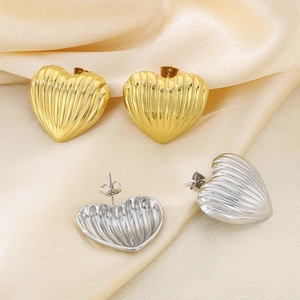 Striped heart stud earrings in gold and silver finish with elegant silk background