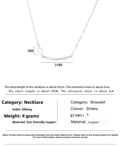 Detail of freshwater pearl necklace featuring a curved metal bar engraved with Freedom