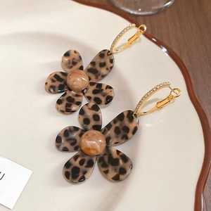 Detailed close-up of leopard print flower earrings with 18K gold plated crystal hoops