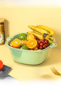 Detail of double-layer vegetable drain basket with green inner colander and clear basin