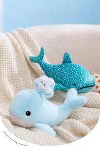Close-up of soft plush whale toys with water droplet detail on a cozy knit blanket