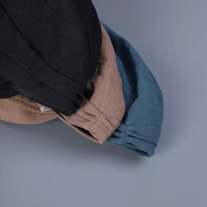 Close-up of breathable linen caps showing elastic back detail in black, tan and blue
