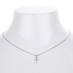 Macro shot of silver cross pendant with sparkling white zircons on a white neck model