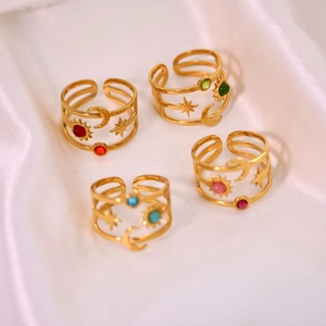 Detailed view of adjustable gold rings featuring celestial patterns and colorful gemstones