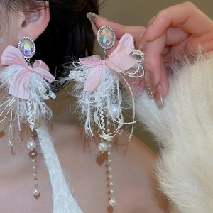 Detail of bow earrings with pink fabric and white faux pearls on a female model