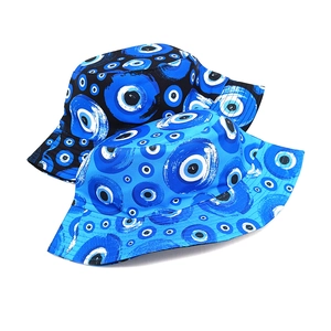 Detail of two bucket hats with evil eye pattern in black and blue canvas fabric