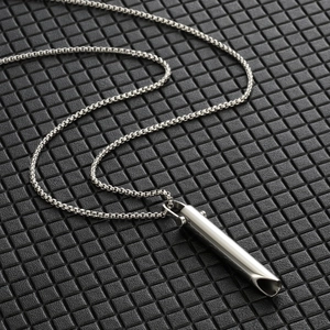 Macro shot of silver meditation breathing pendant with sleek box chain on dark texture