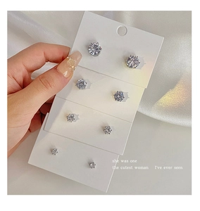 Detailed view of four pairs of silver stud earrings with sparkling cubic zirconia on card