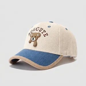 Detail of waffle-textured cotton fabric on kids baseball cap with brown bear embroidery