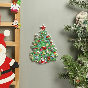 Detail of Christmas tree resin magnet with Santa and snowman on a soft green wall