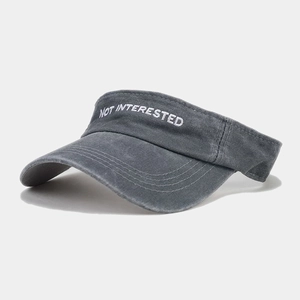 Detail of the NOT INTERESTED embroidery and vintage washed cotton on dark grey visor hat
