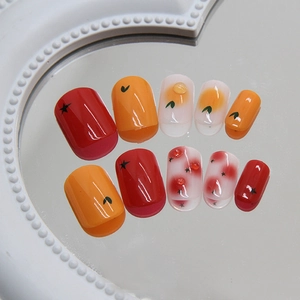 24pcs short fruit press-on nails with stars, orange tints, and red 3D gems on a mirror