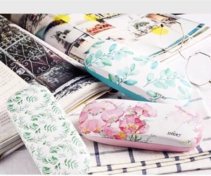 Detailed view of three stylish fabric texture glasses cases with floral and leaf patterns