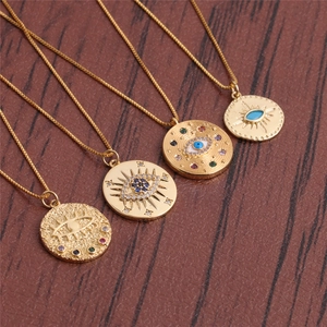 Gold evil eye pendant necklaces with colorful zircon accents on dark wood background