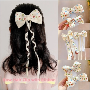Close-up of colorful polka dot bow hair clips with long streamers for girls
