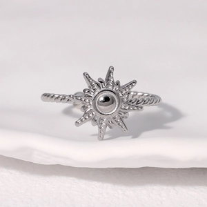 Silver stainless steel sunburst open ring with twisted rope band on white ceramic