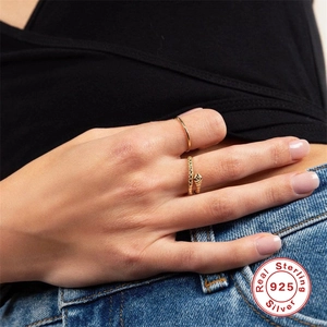Detail of S925 sterling silver snake ring and minimalist gold band on model finger