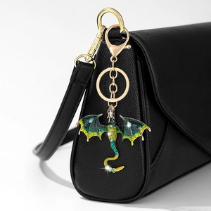 Detail of a gold dragon keychain featuring green enamel gradient and sparkling rhinestones