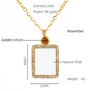 Detail of 18K gold plated necklace with shell pendant and November zircon specs