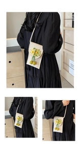Detail view of handmade woven phone bag with yellow daisy accents and crossbody strap