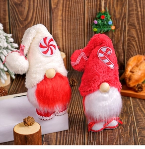 Detail view of plush Christmas gnomes with candy-themed hats on a wooden surface